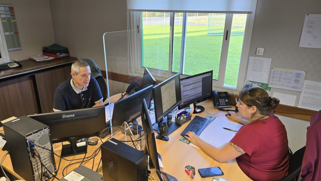 Des collaborateurs du site de Saint-Pardoux-La-Rivière en Dordogne des Transports Gauthier assis derrière leurs bureaux et travaillant sur des ordinateurs. L'image montre un environnement de bureau moderne, avec des équipements informatiques et des outils de gestion de stockage et logistique.