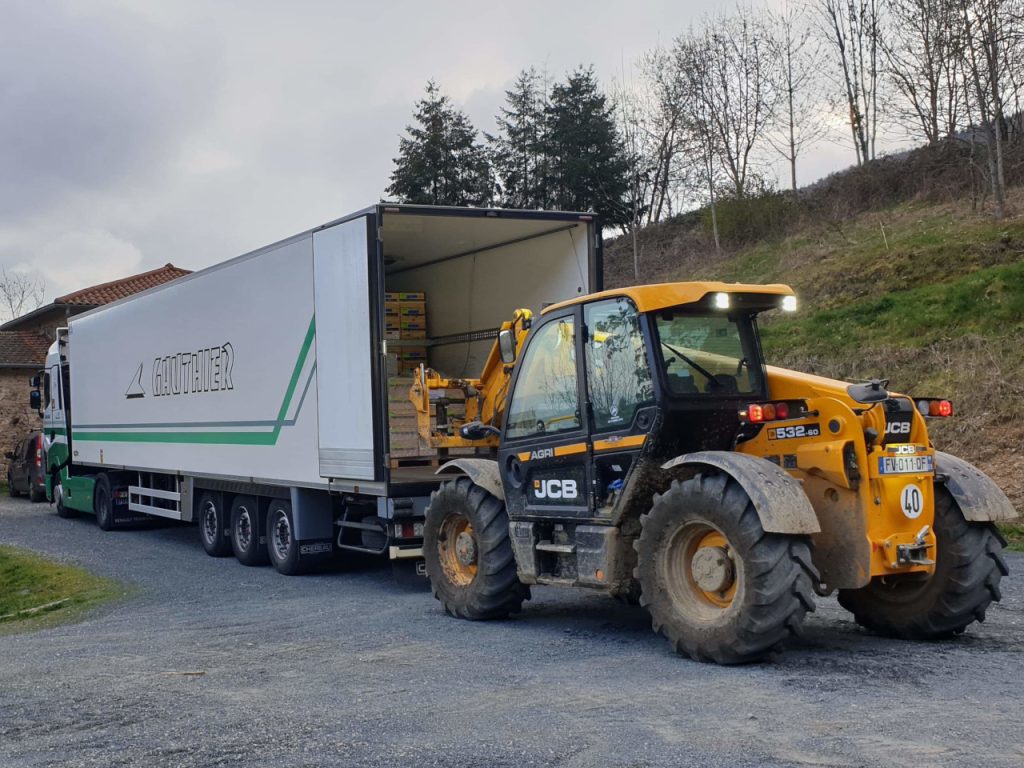 Palette déchargée d'un camion des Transports Gauthier à l'aide d'un tracteur lors d'une livraison.