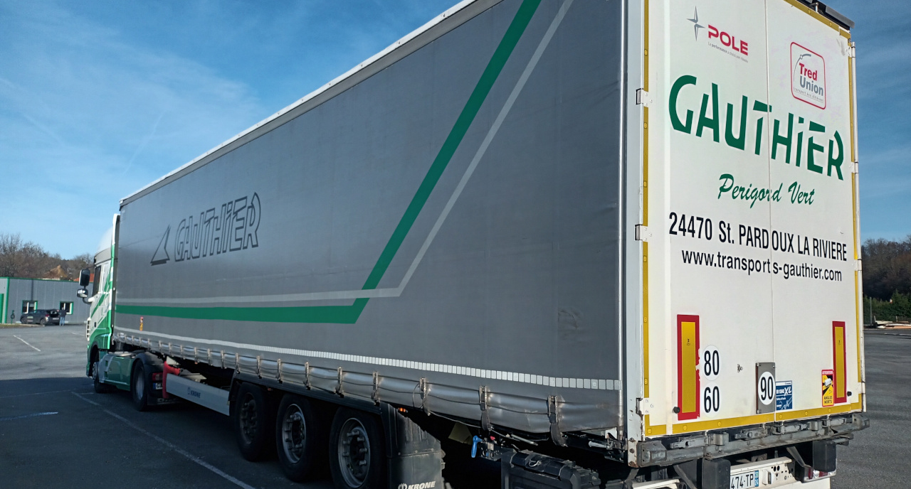 Camion tautliner des Transports Gauthier stationné sur le parc logistique en Dordogne, prêt pour de nouvelles expéditions.